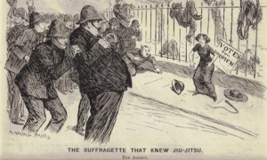 A Victorian cartoon. A woman stands against a fence, with several unconscious police officers draped over it. More police officers balk at arresting her. The woman has a belligerent demeanor.