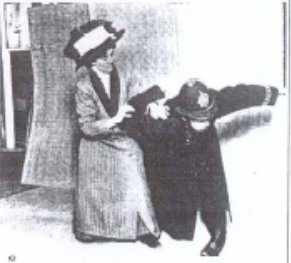 A black and white photo of a woman in Edwardian clothing holding a British police officer in a joint lock