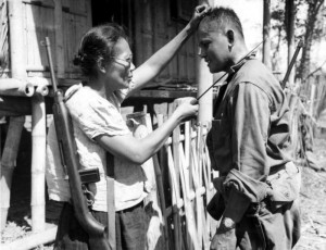 A Huk woman shows an American GI how it's done.
